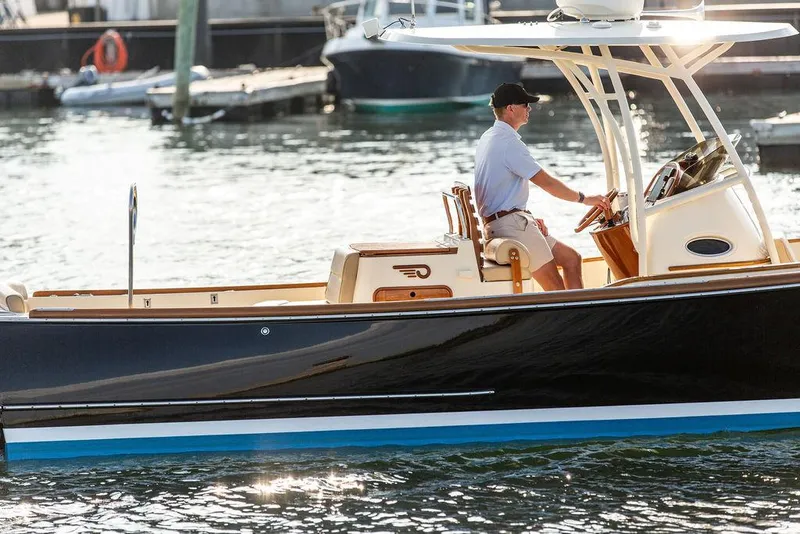 Slide: The Image of 2014 Hinckley T29 CC boat cruising on water with a person at the helm. - 23