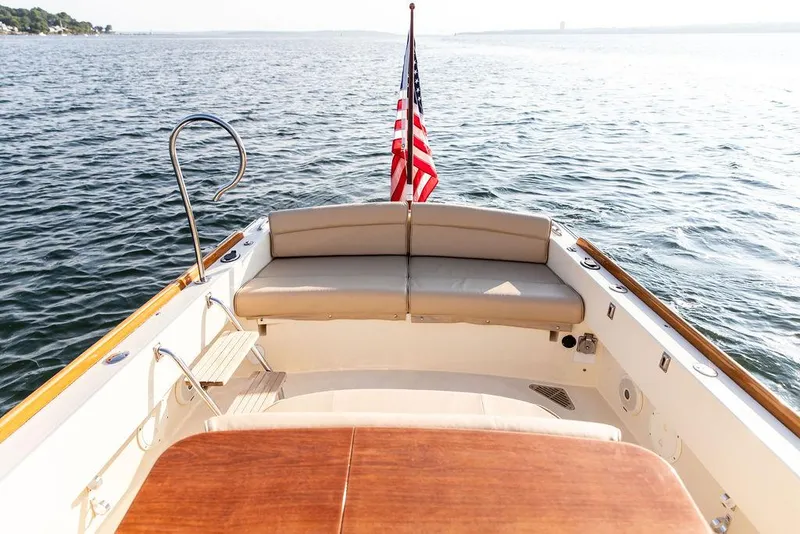 Slide: The Image of 2014 Hinckley T29 CC boat with American flag on calm water. - 33
