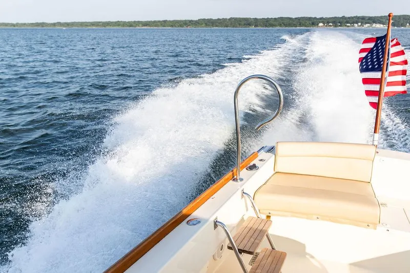 Slide: The Image of Hinckley T29 CC 2014 boat cruising on open water with American flag. - 36