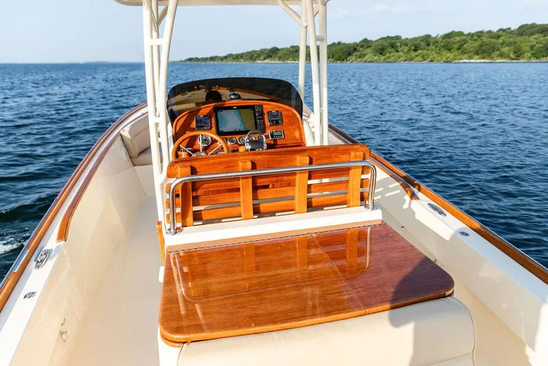 Slide: The Image of 2014 Hinckley T29 CC boat with polished wood interior on open water. - 43