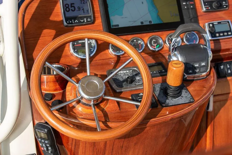 Slide: The Image of Helm of 2014 Hinckley T29 CC boat with wooden steering wheel and navigation controls. - 48