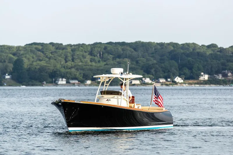 Slide: The Image of 2014 Hinckley T29 CC boat cruising on a calm lake with forested shoreline. - 7
