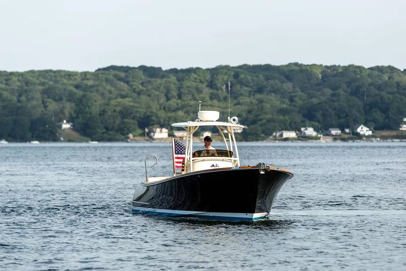 Slide: The Image of 2014 Hinckley T29 CC boat cruising on a calm lake with forested shoreline. - 9