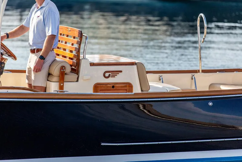 Slide: The Image of 2014 Hinckley T29 CC boat with wooden seating and elegant design on calm water. - 25