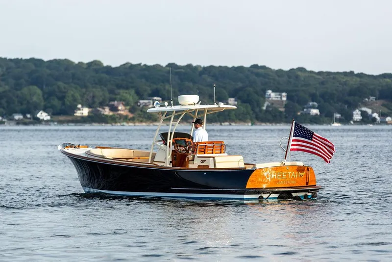 Slide: The Image of 2014 Hinckley T29 CC boat on water, American flag, scenic shoreline background. - 3