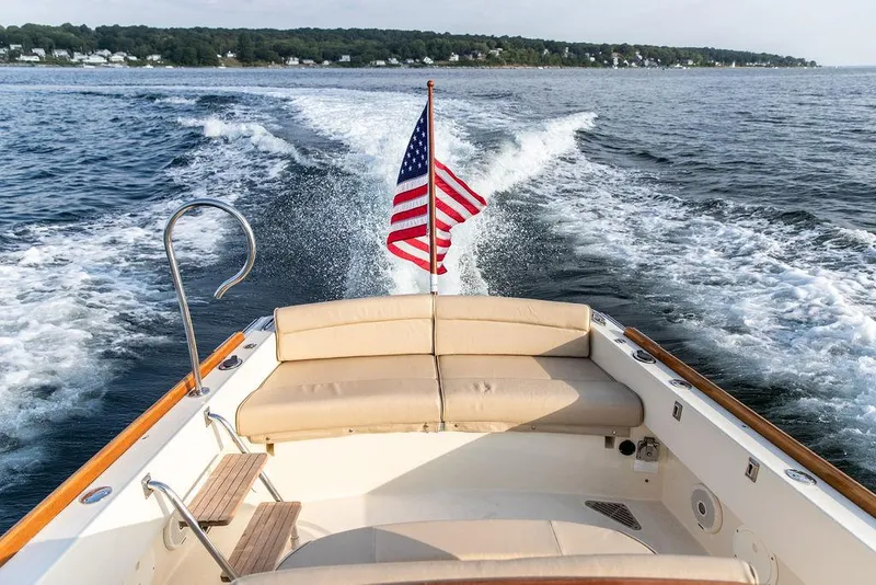 Slide: The Image of 2014 Hinckley T29 CC boat cruising with American flag, scenic ocean view. - 32