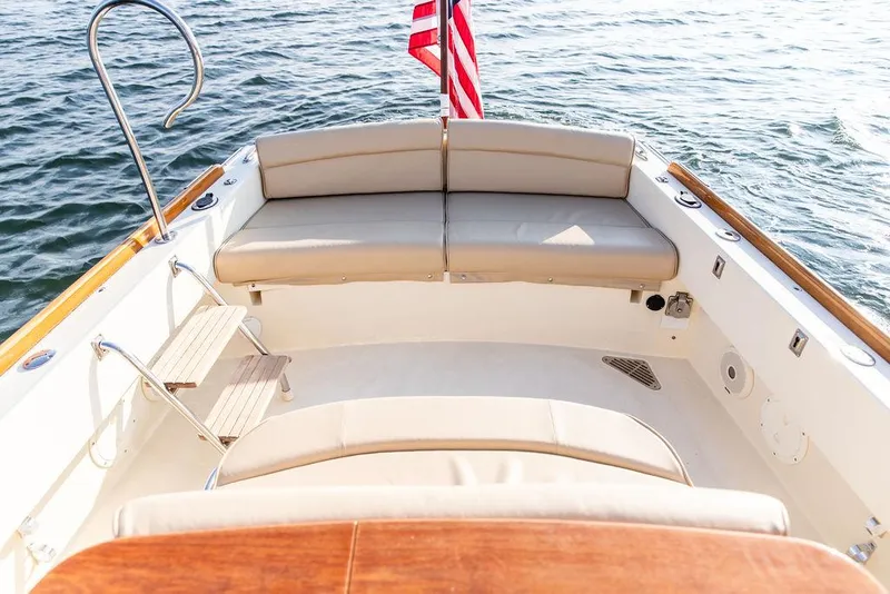 Slide: The Image of 2014 Hinckley T29 CC boat interior with seating and American flag on water. - 34