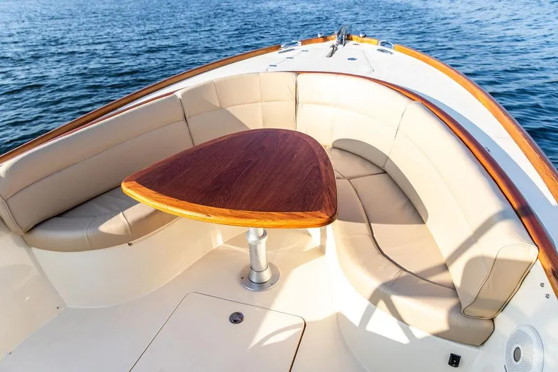 Slide: The Image of 2014 Hinckley T29 CC boat interior with elegant seating and wooden table on the water. - 39