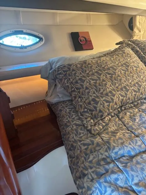 Slide: The Image of Cozy cabin interior of 2007 Monterey 350 Sport Yacht with patterned bedding and porthole window. - 33