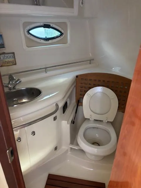 Slide: The Image of 2007 Monterey 350 Sport Yacht bathroom with sink, toilet, and porthole window. - 34