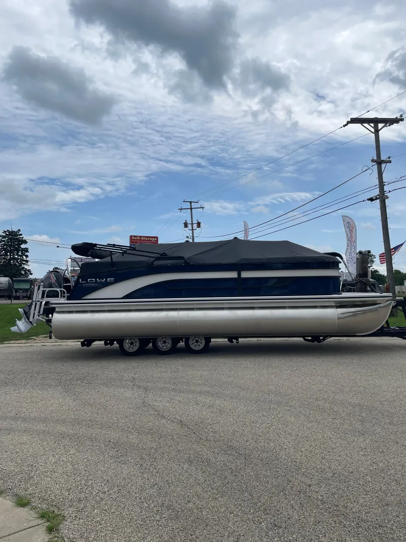 Slide: The Image of 2026 Lowe SS 230 WT Special pontoon boat on trailer under cloudy sky. - 1