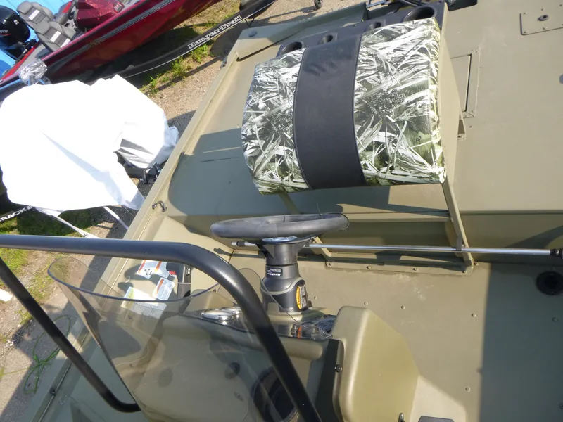Slide: The Image of 2024 Tracker Grizzly 2072 CC Sportsman boat interior with camo seat and steering console. - 11