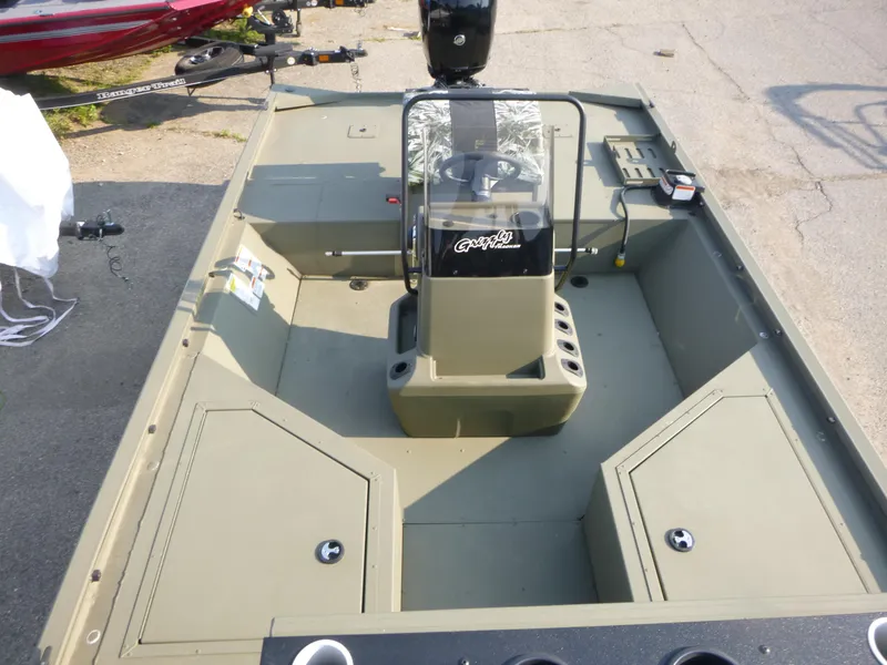 Slide: The Image of 2024 Tracker Grizzly 2072 CC Sportsman boat interior with steering console and storage compartments. - 6