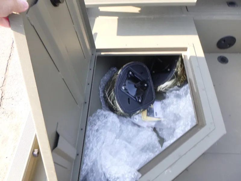 Slide: The Image of Open storage compartment in 2024 Tracker Grizzly 2072 CC Sportsman boat, containing packaged items. - 9