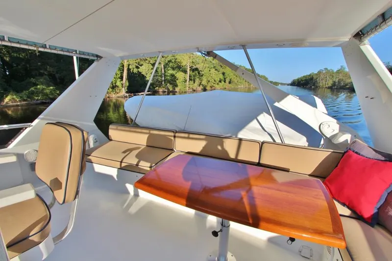 Slide: The Image of 1992 Tollycraft 53 Motor Yacht interior with seating and table, overlooking serene waterway. - 19