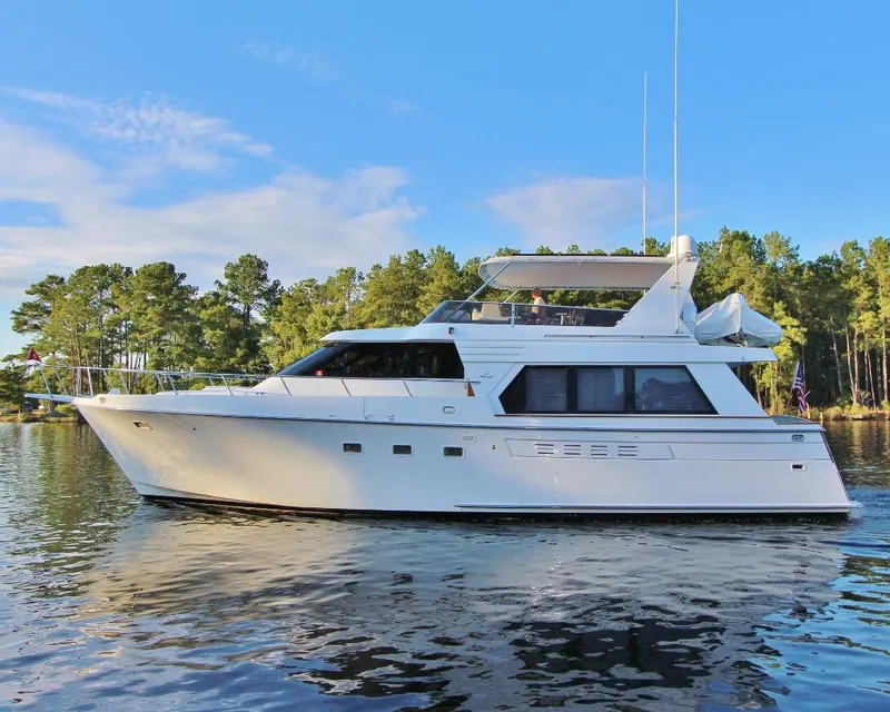 Slide: The Image of 1992 Tollycraft 53 Motor Yacht on serene water, surrounded by lush trees. - 2