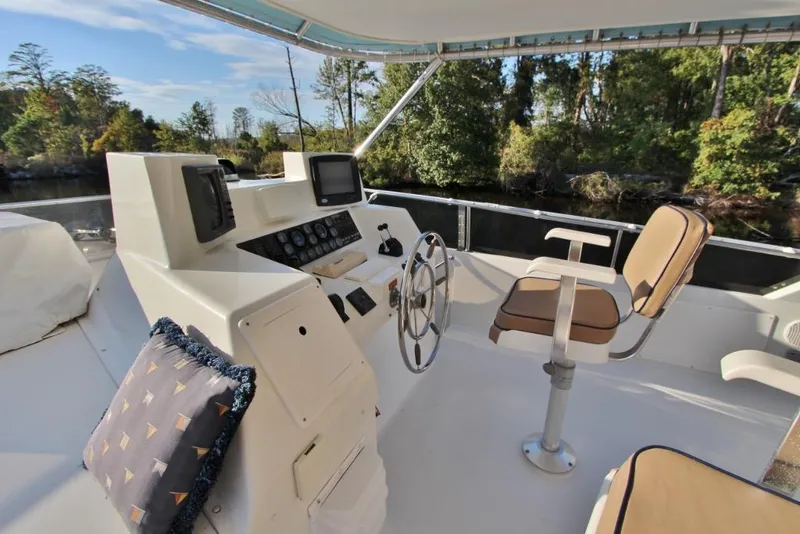 Slide: The Image of 1992 Tollycraft 53 Motor Yacht helm with steering wheel, controls, and cushioned seating. - 20