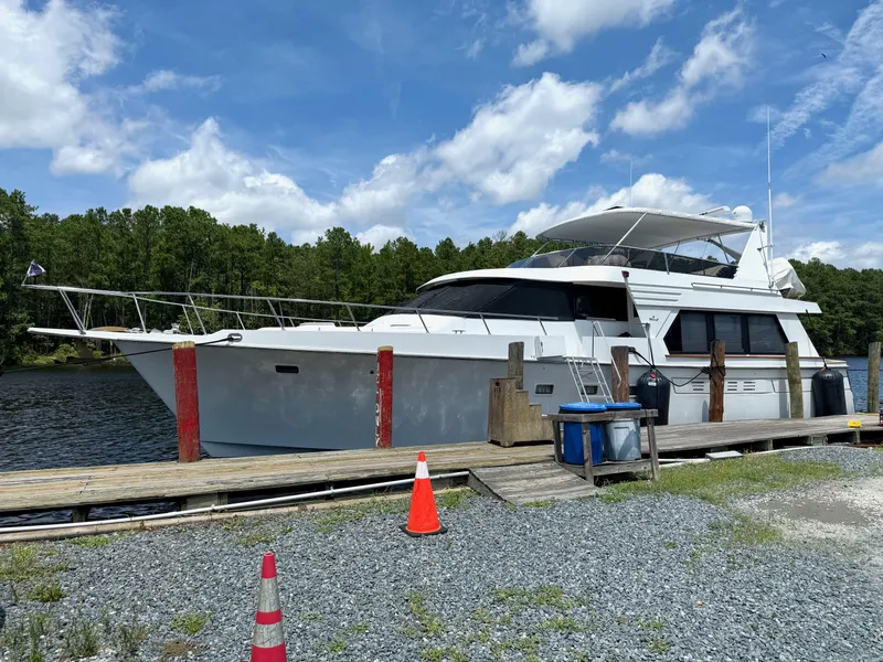 Slide: The Image of 1992 Tollycraft 53 Motor Yacht docked by a serene lake under a blue sky. - 25