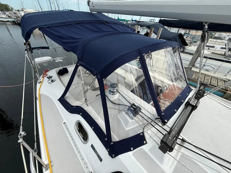 Slide: The Image of 2007 Catalina 309 sailboat with blue canopy docked at marina. - 11