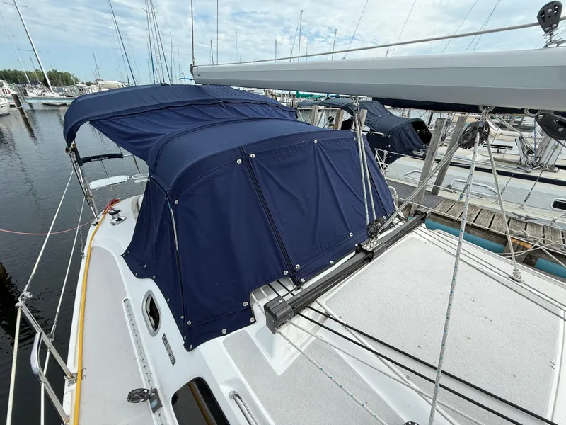 Slide: The Image of 2007 Catalina 309 sailboat with blue canvas cover docked at marina. - 13