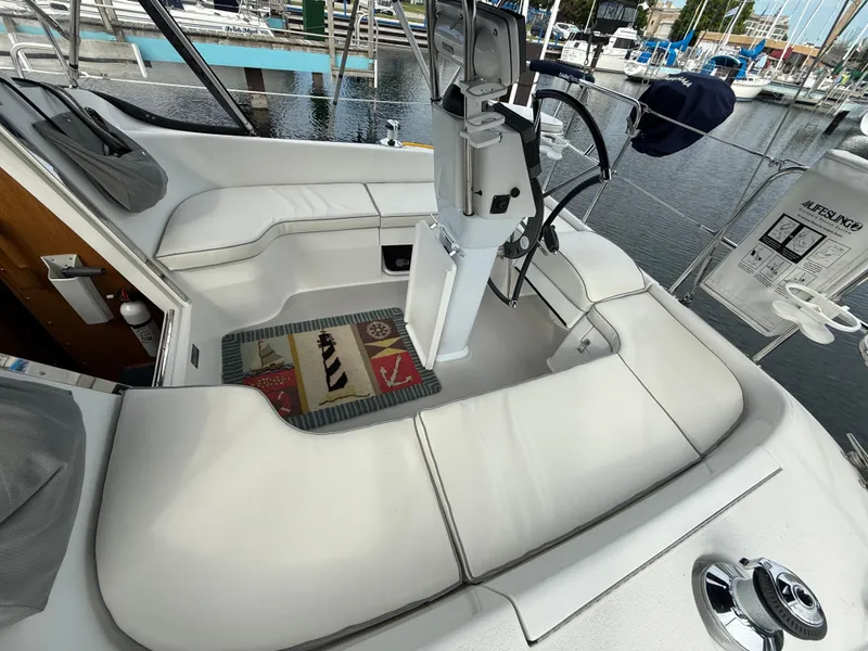 Slide: The Image of Cockpit of a 2007 Catalina 309 sailboat with white seating and nautical decor. - 16