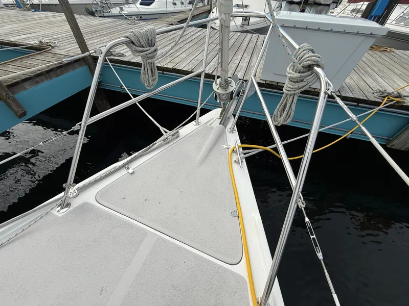 Slide: The Image of Bow of 2007 Catalina 309 sailboat docked, featuring deck and mooring lines. - 34