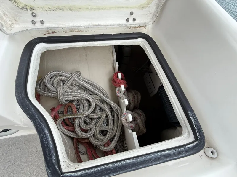Slide: The Image of Open storage compartment on 2007 Catalina 309 sailboat with coiled ropes inside. - 36
