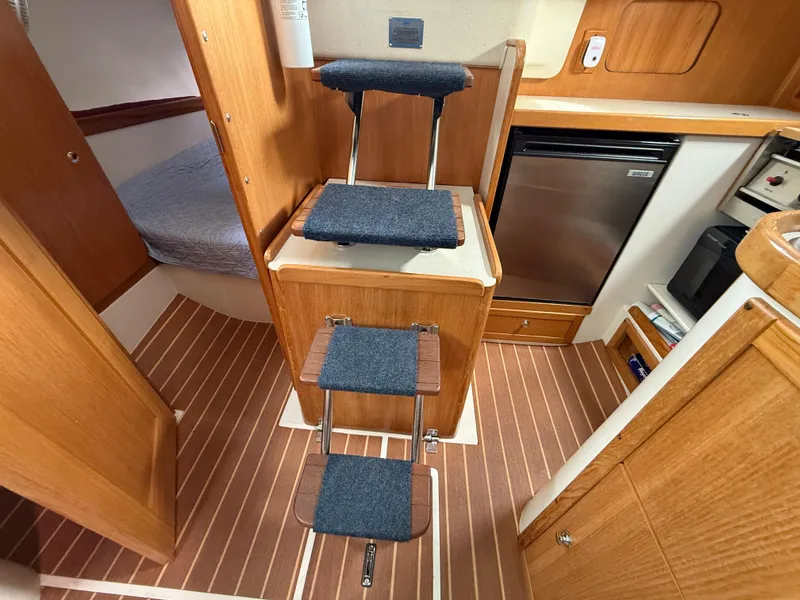 Slide: The Image of Interior of 2007 Catalina 309 sailboat with wooden steps and compact kitchen area. - 42