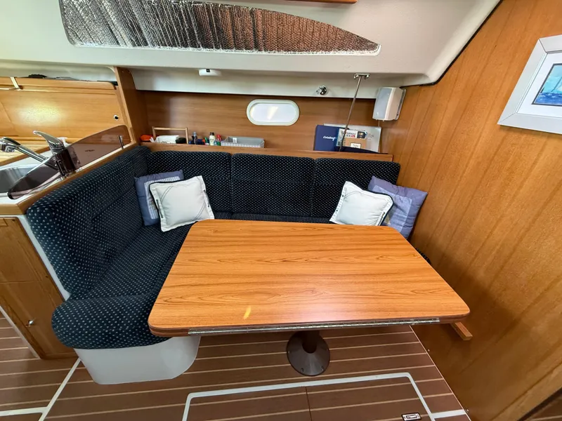 Slide: The Image of Cozy dining area in a 2007 Catalina 309 sailboat with wooden table and cushioned seating. - 45