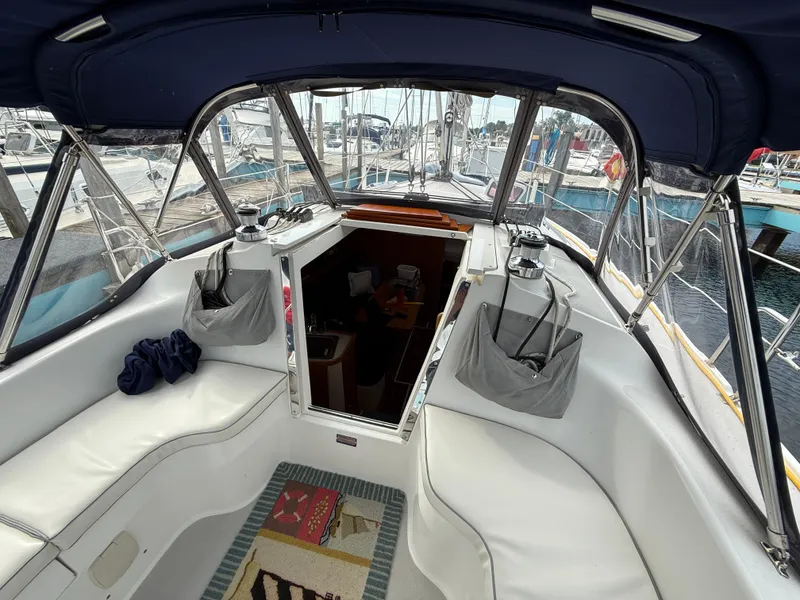 Slide: The Image of Interior view of a 2007 Catalina 309 sailboat cockpit with seating and marina background. - 9