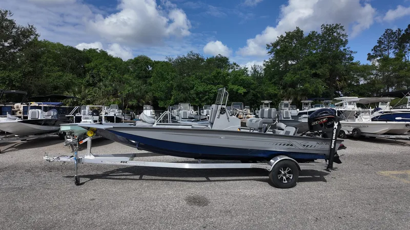 Slide: The Image of 2026 Xpress H20B boat on trailer, parked in a marina with other boats. - 6
