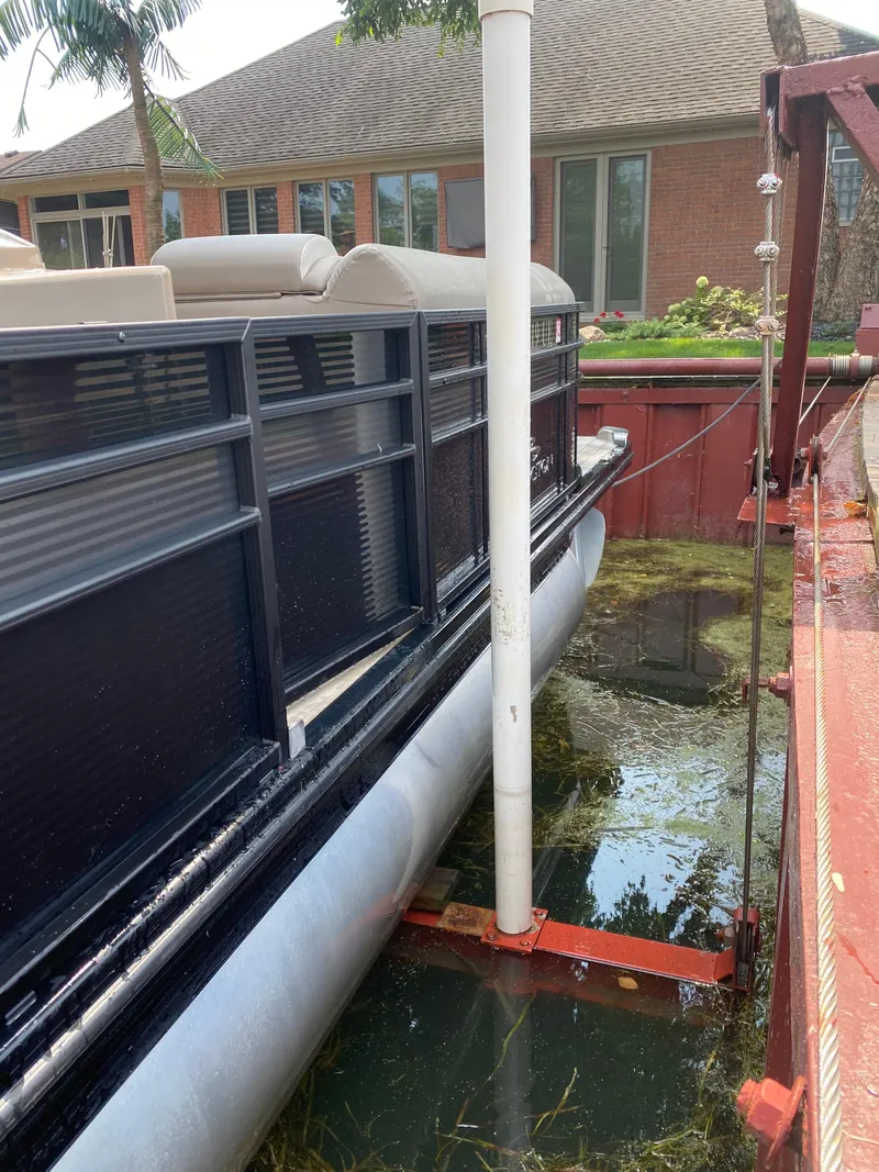 Slide: The Image of 2018 Bennington 25 GCW pontoon boat docked near a brick house. - 10