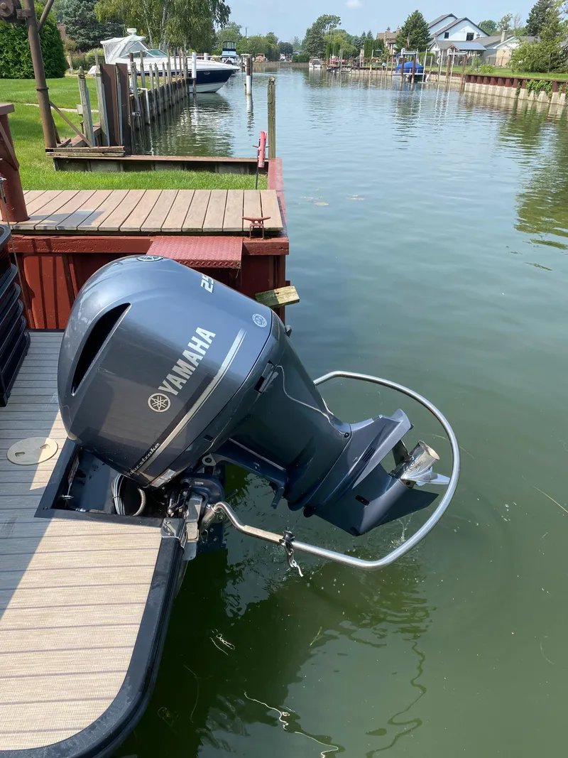 Slide: The Image of 2018 Bennington 25 GCW with Yamaha outboard motor docked by a canal. - 12