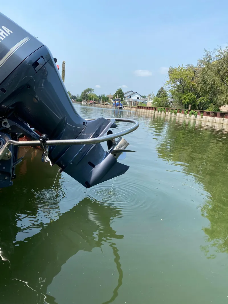Slide: The Image of Outboard motor of a 2018 Bennington 25 GCW boat on calm water. - 13