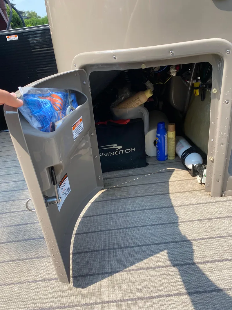Slide: The Image of Open storage compartment on 2018 Bennington 25 GCW boat, containing various items. - 16