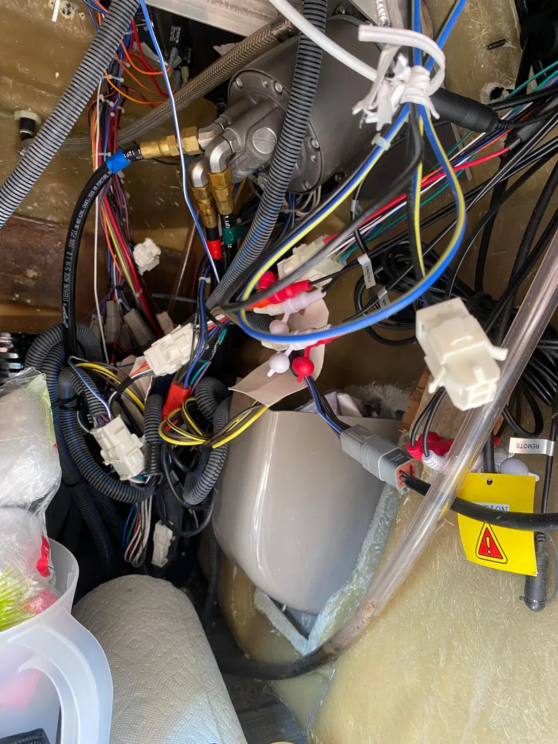 Slide: The Image of Tangled wiring inside a 2018 Bennington 25 GCW boat, showcasing complex electrical connections. - 17