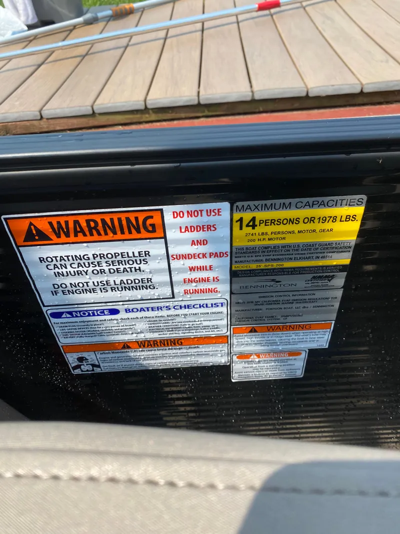 Slide: The Image of Warning labels on a 2018 Bennington 25 GCW boat, indicating safety and capacity limits. - 23