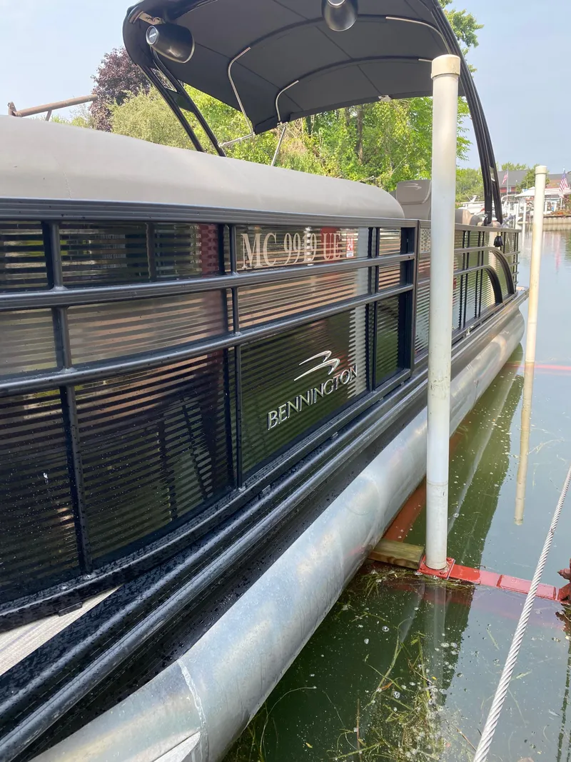 Slide: The Image of 2018 Bennington 25 GCW pontoon boat docked on a calm lake. - 8