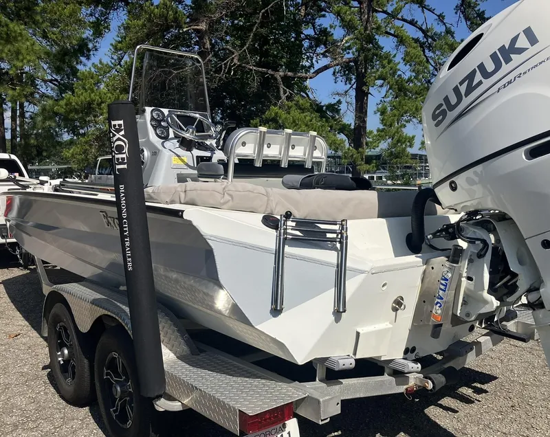 Slide: The Image of 2022 Excel 220 Bay Pro boat with Suzuki engine on trailer, parked outdoors. - 14