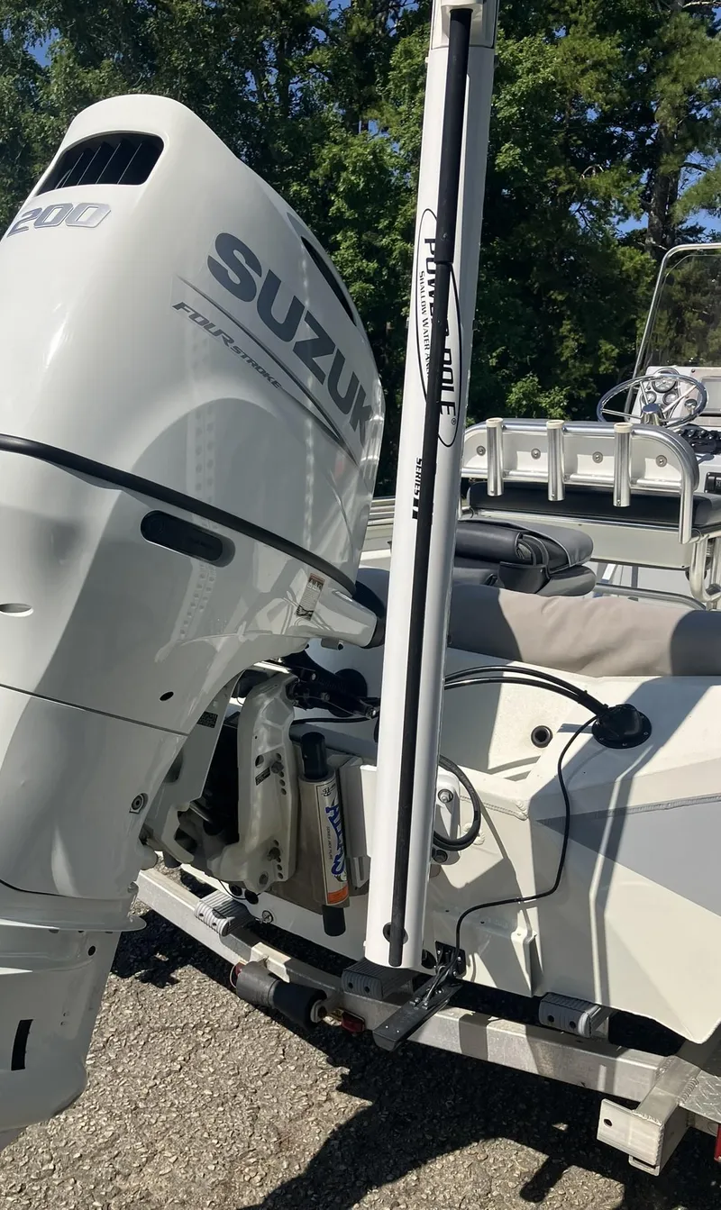 Slide: The Image of 2022 Excel 220 Bay Pro boat with Suzuki outboard motor, parked on a trailer. - 18