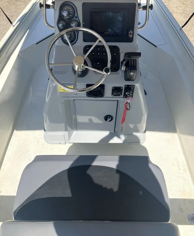 Slide: The Image of 2022 Excel 220 Bay Pro boat console with steering wheel and controls. - 6