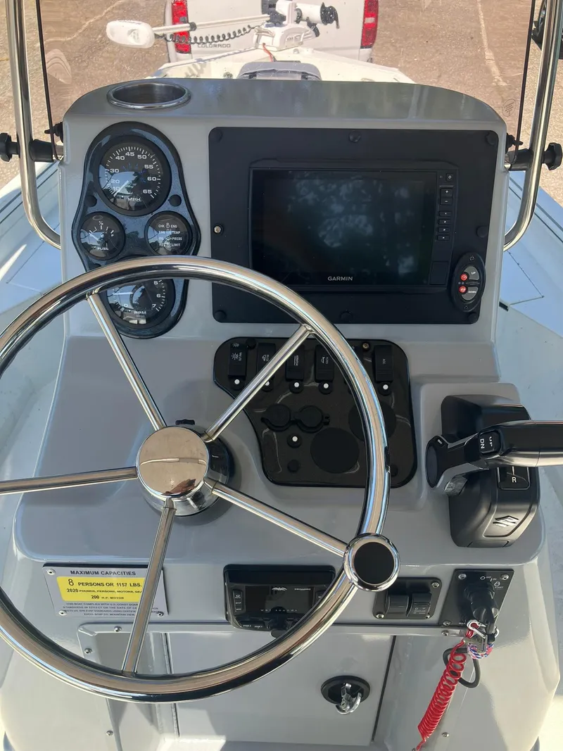Slide: The Image of 2022 Excel 220 Bay Pro boat dashboard with steering wheel and control panel. - 7