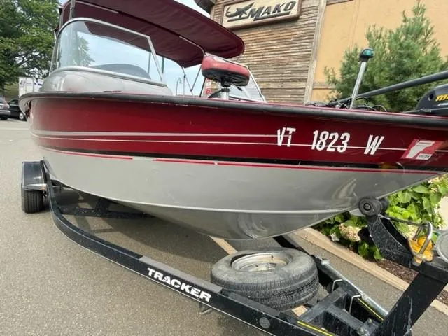Slide: The Image of 2014 Tracker Targa V-18 Combo boat on trailer, red and silver, parked outdoors. - 10