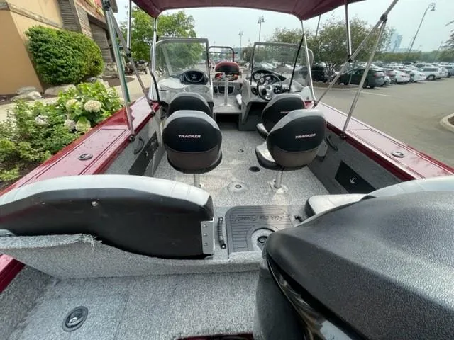 Slide: The Image of 2014 Tracker Targa V-18 Combo boat interior with seating and steering wheel, parked outdoors. - 3