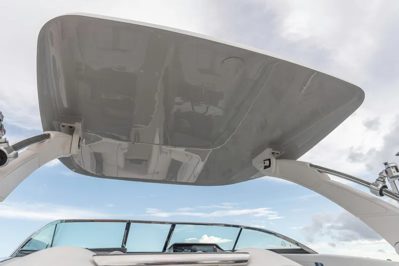 Slide: The Image of 2026 Regal LS9 Surf boat with sleek canopy against a cloudy sky. - 15