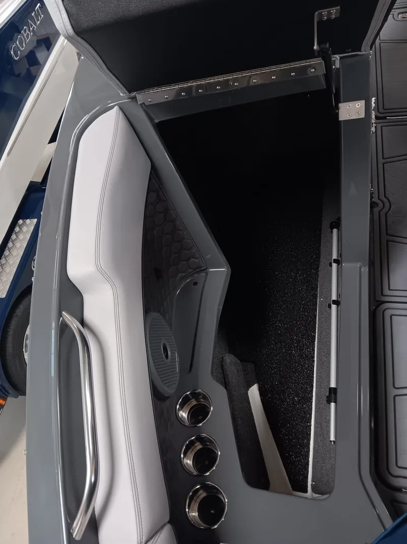 Slide: The Image of 2026 Cobalt R4 Surf boat interior storage compartment with sleek design and metallic accents. - 7