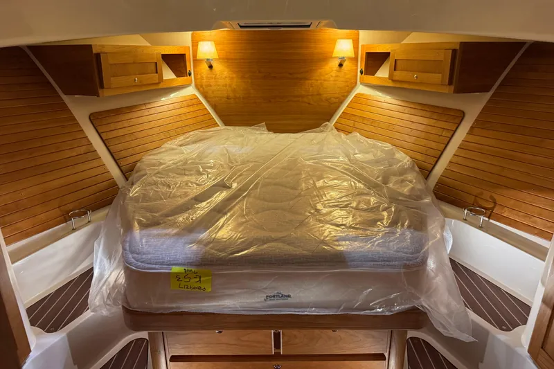 Slide: The Image of 2026 Back Cove 39O boat interior with striped seating and glass doors in a storage facility. - 11