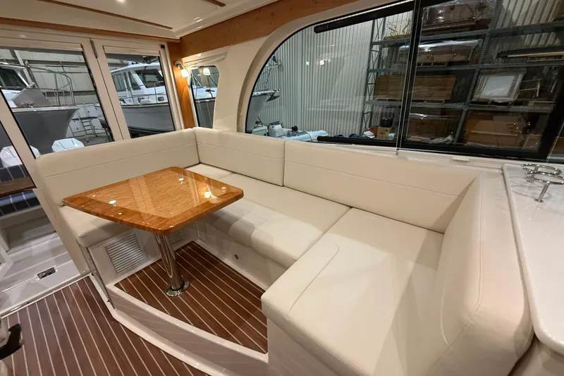 Slide: The Image of 2026 Back Cove 39O yacht interior with white seating and wooden table. - 22