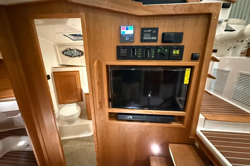 Slide: The Image of Interior of 2026 Back Cove 39O yacht with control panel, TV, and bathroom. - 28