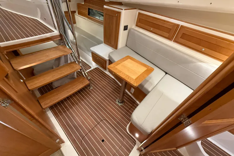 Slide: The Image of 2026 Back Cove 39O yacht interior with wooden stairs, seating, and table. - 31